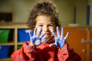 young girl with paint on her hands
