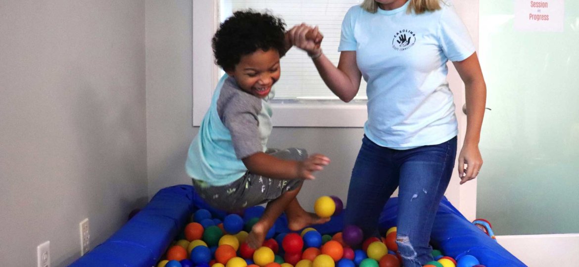 young boy in ball pit with CTC staff member
