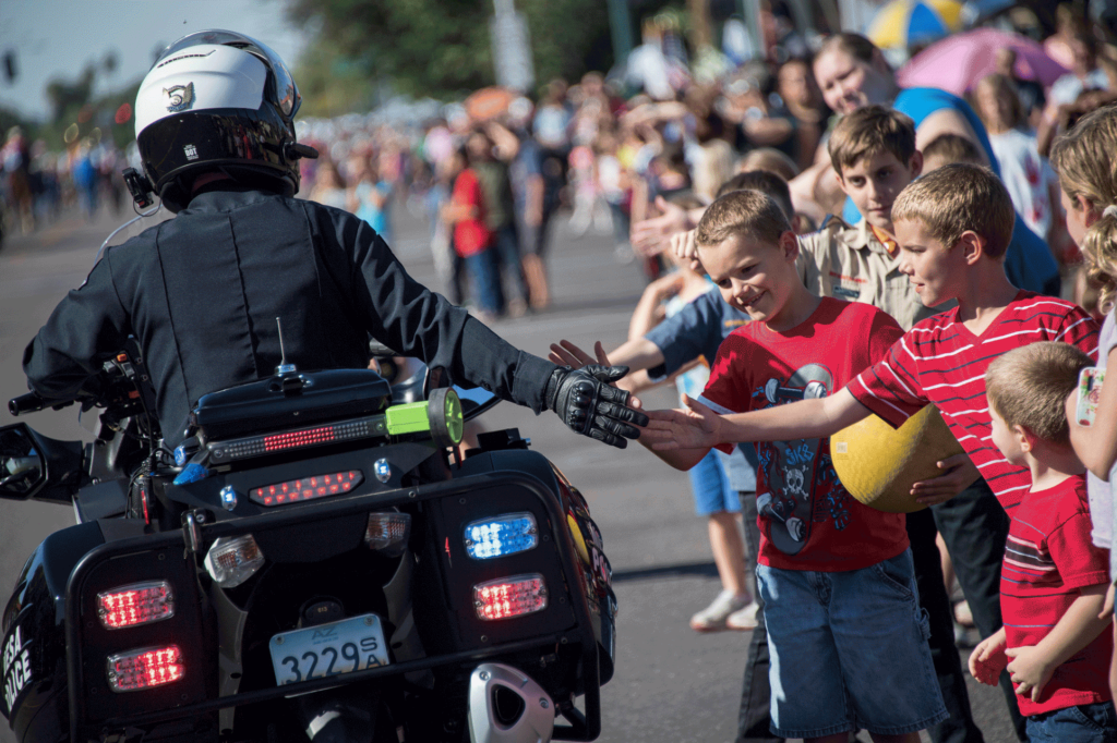 Mesa PD motor cop high fiving kids